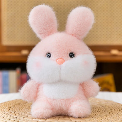 Cute Small Pink plush bunny toy on a woven surface with a blurred background