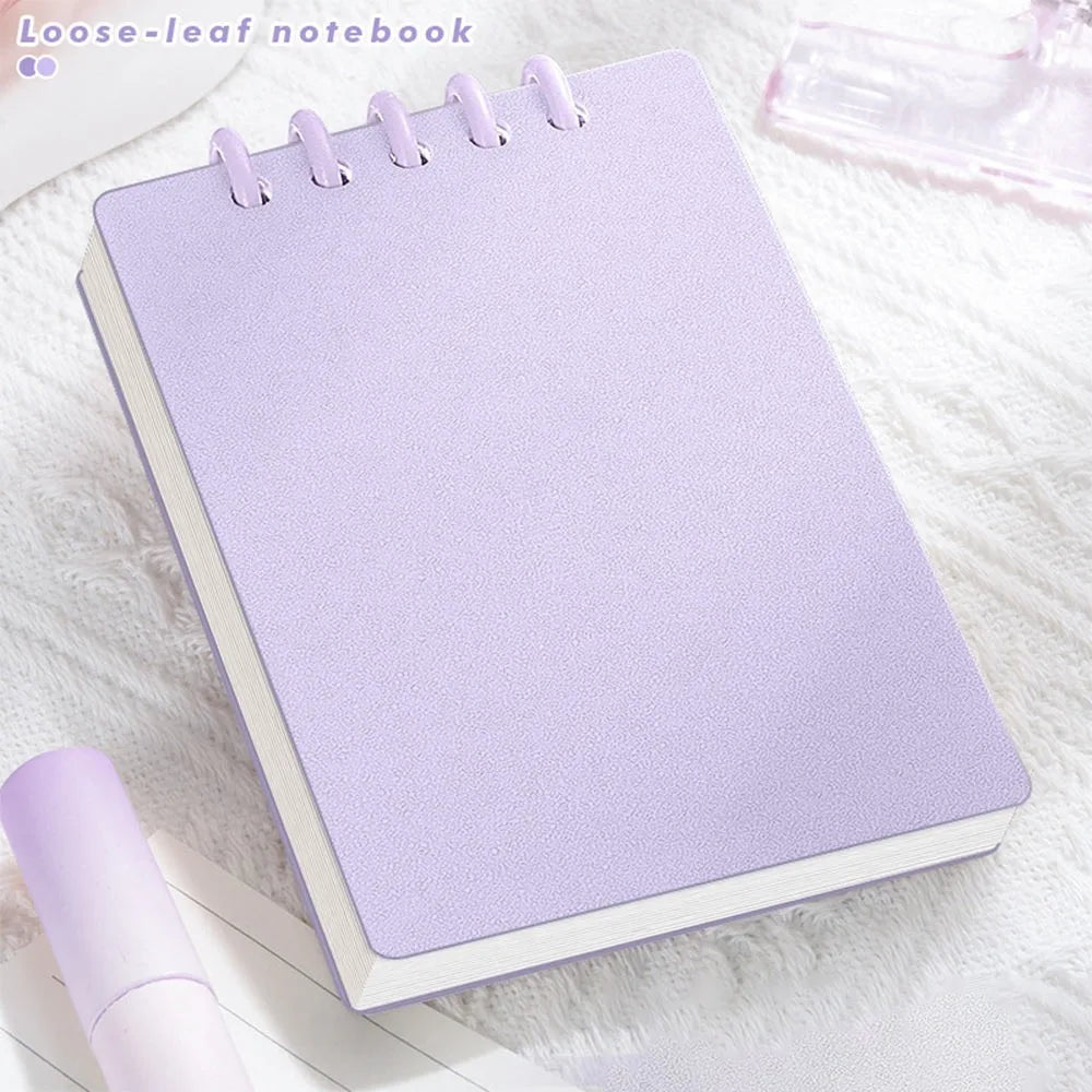 Cute Small notepad with light Pastel purple cover and lined pages on a white linen surface.